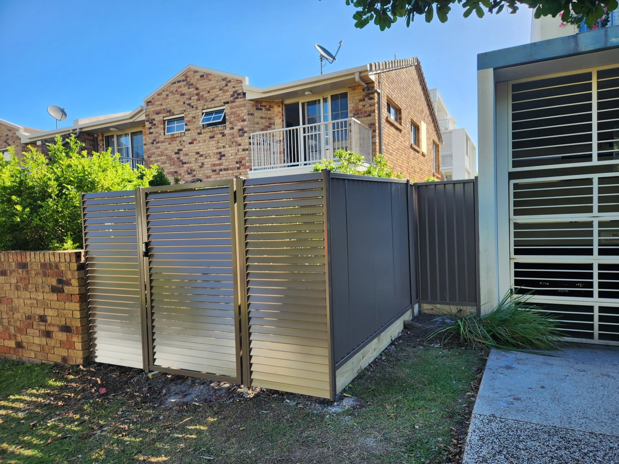 Black Colorbond privacy fence with matching bronze aluminium slat gate