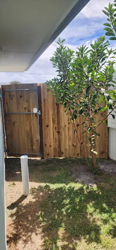 New timber paling side gate with round handle beside a rendered home